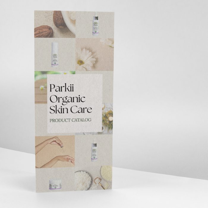 A tri-fold brochure standing upright on a white surface, featuring the Parkii Organic Skin Care logo and natural imagery of shea nuts, flowers, and botanical textures.