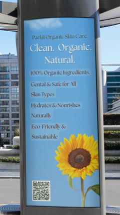 Tall outdoor pillar advertisement for Parkii Organic Skin Care featuring the tagline "Clean. Organic. Natural." with details about 100% organic, eco-friendly ingredients and a large sunflower image at the bottom.